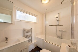 Un baño con ducha, inodoro y lavamanos.