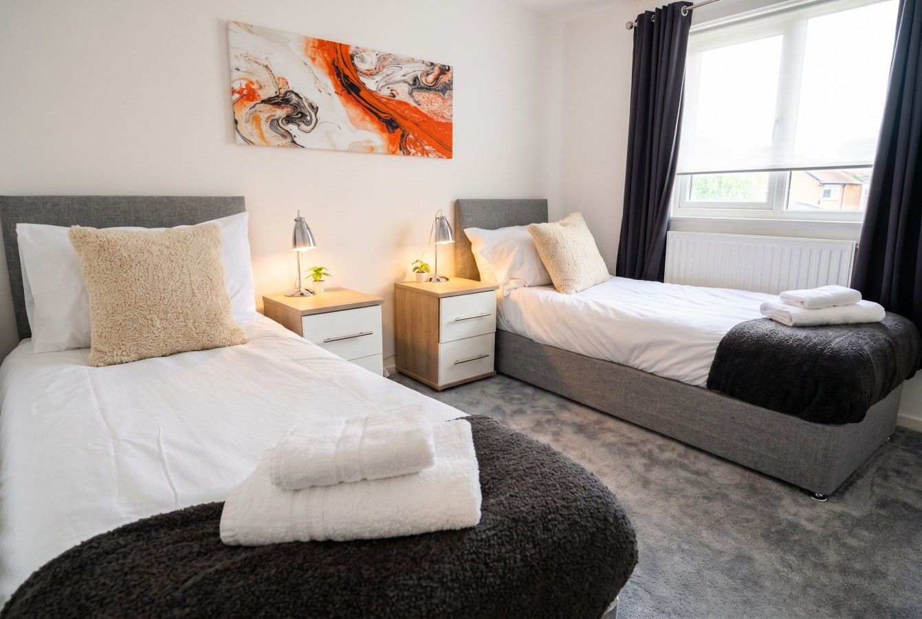 Second twin room with paired singles and bedside storage between them.