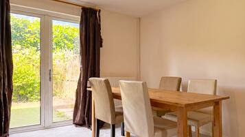 Dining table seats four beside the garden doors.