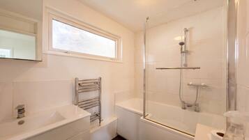 Bathroom with bathtub, shower screen and heated towel rail.