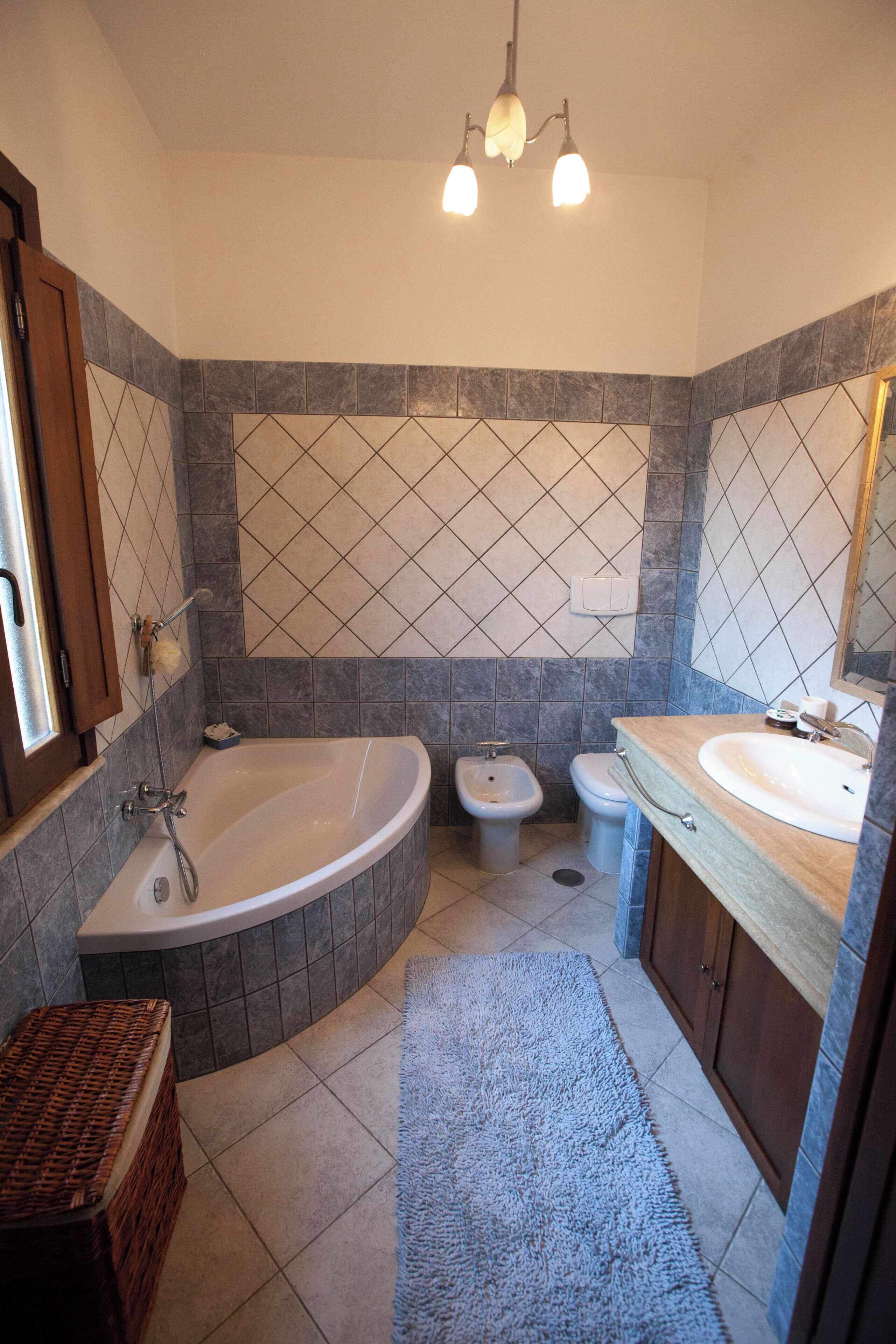 Une salle de bain avec une baignoire sur pieds, un bidet, des toilettes et un meuble-lavabo avec un évier.