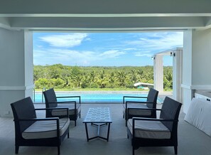 A balcony with a view of a swimming pool and lush greenery.