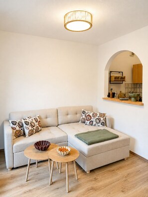 A modern living room with a sofa, a coffee table, and a hanging light fixture. - Vacation rental for 4 people, 1 separate bedroom, balcony, 54 m² (Inzell)