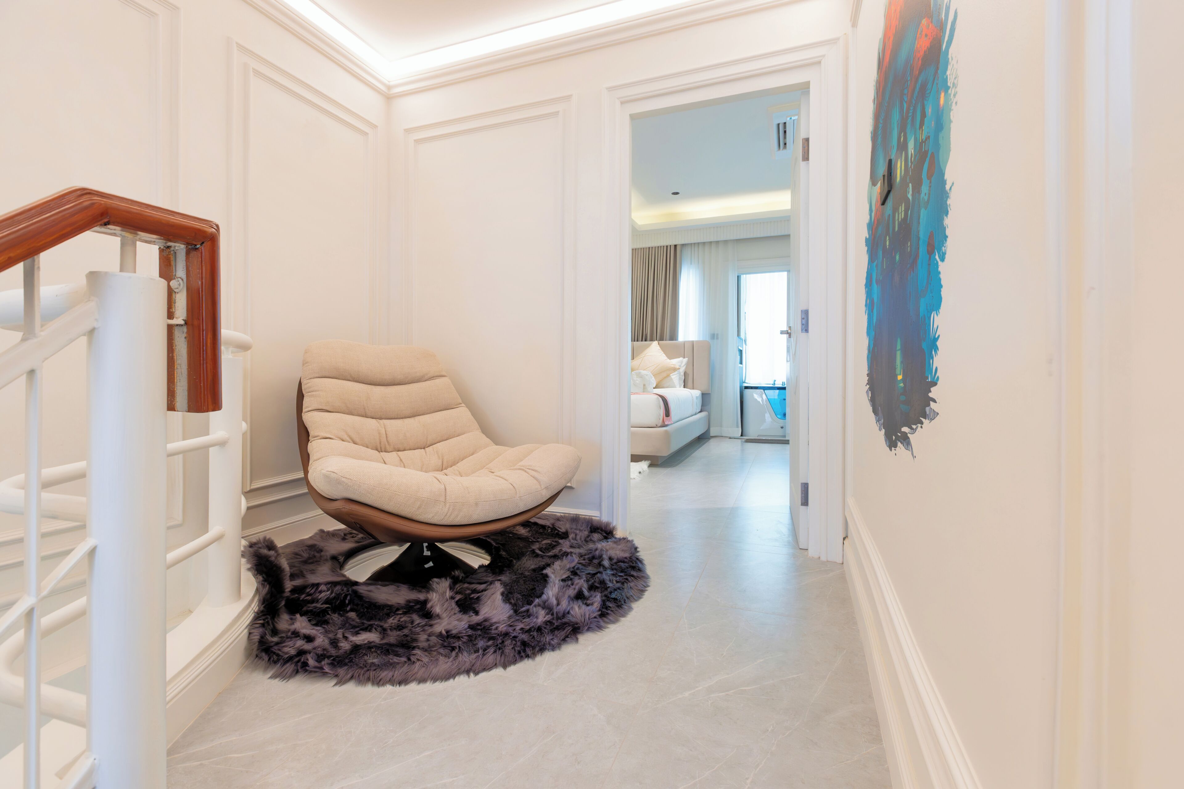 Un interior moderno con una silla, una alfombra mullida y una escalera.