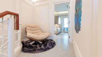 Un interior moderno con una silla, una alfombra mullida y una escalera.