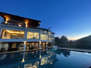 Un edificio a più piani con una piscina di fronte.