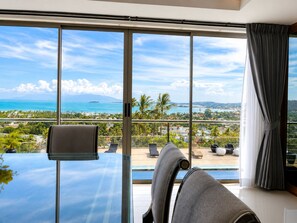 A room with a large window overlooking a pool and a scenic view of a coastline. - Smith & Appy Luxury Seaview Penthouse (Koh Samui)