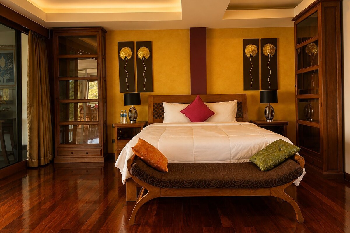Una camera d'albergo con un letto grande, due comodini, una panca in legno e vista attraverso una porta in vetro.