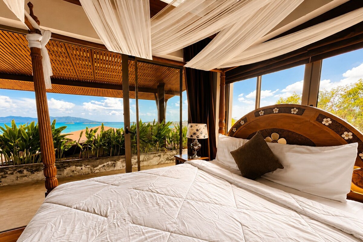 Un letto con vista sulla spiaggia, una testiera in legno e una tenda da baldacchino.