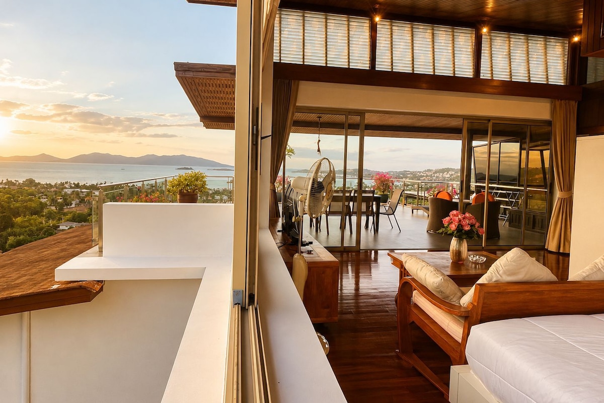 Un interno moderno con un balcone che si affaccia su un panorama suggestivo di mare e montagne.