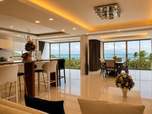 Una habitación de hotel moderna con balcón, zona de comedor y cocina.