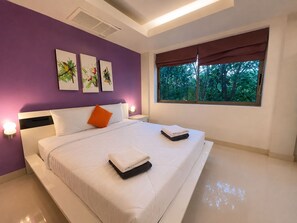 A modern bedroom with a large bed, a window with a view of trees, and three wall-mounted artworks. - Smith & Appy Luxury Seaview Penthouse (Koh Samui)