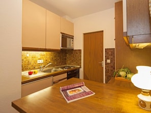 A compact kitchen with a wooden countertop, a built-in microwave, and a sink. - Rotter/seelord 27 (Norderney)