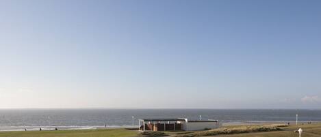 A coastal building with a pathway leading to the beach.