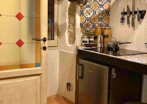 Eine Küche mit gefliestem Fliesenspiegel, einem Kühlschrank und verschiedenen Küchengeräten und Utensilien.
