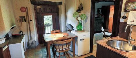 A compact kitchen with a wooden table, a white refrigerator, and a sink.