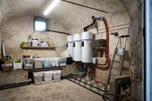 Une pièce utilitaire contenant des chauffe-eau, des étagères de rangement et divers tuyaux.