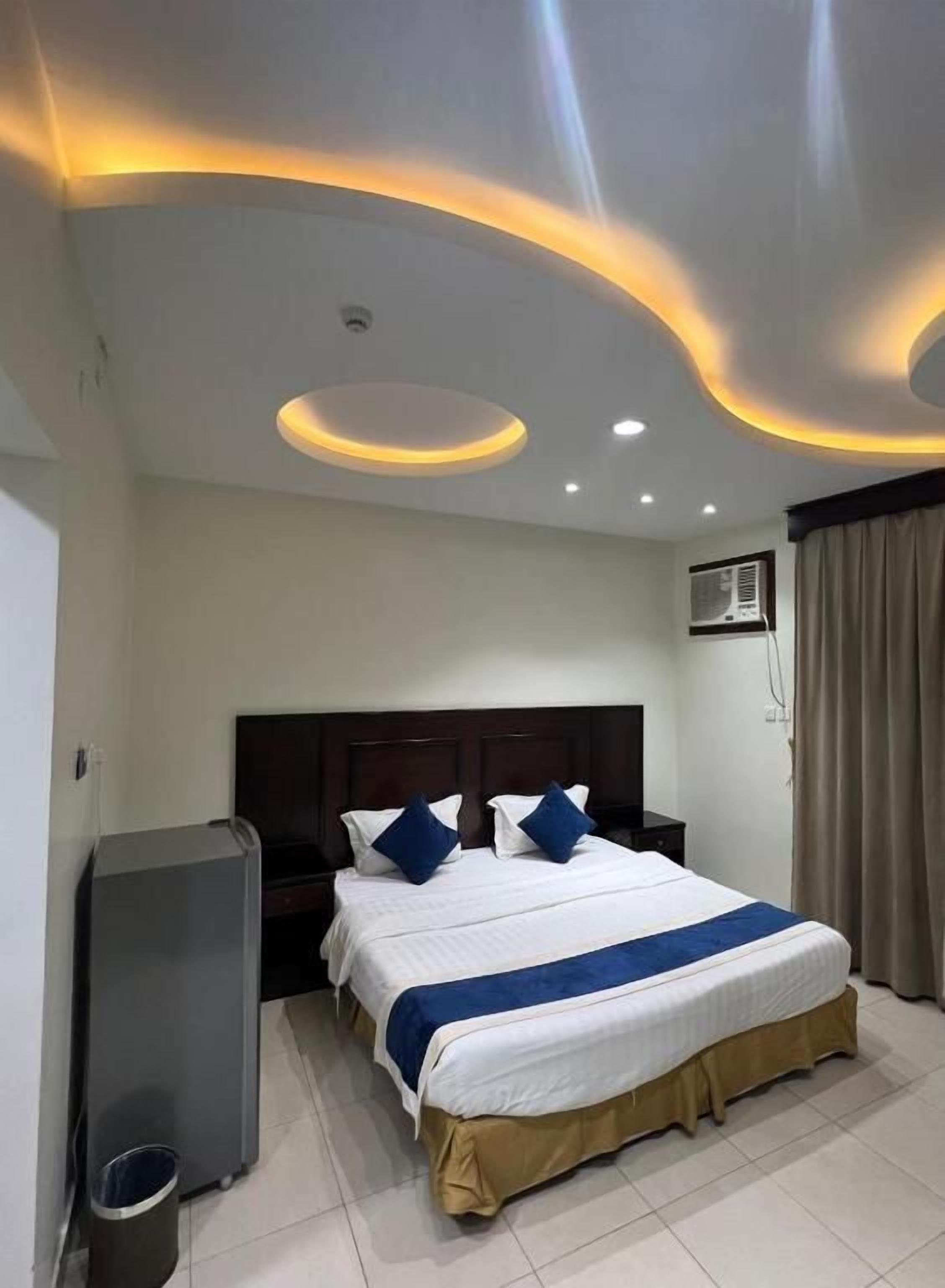Una habitación de hotel con una cama, un escritorio y un cesto de basura.