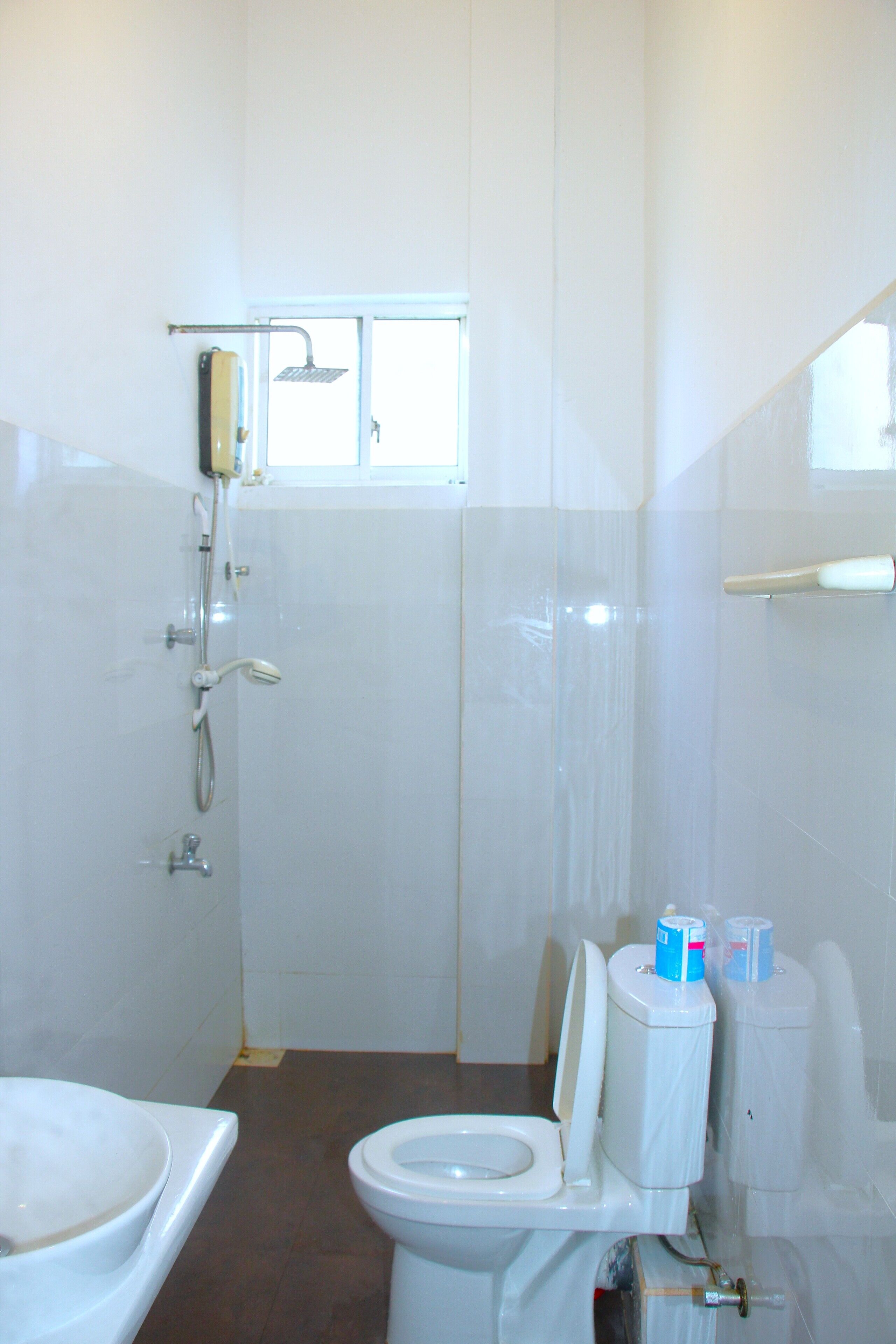 A bathroom with a toilet, a shower, and a sink.