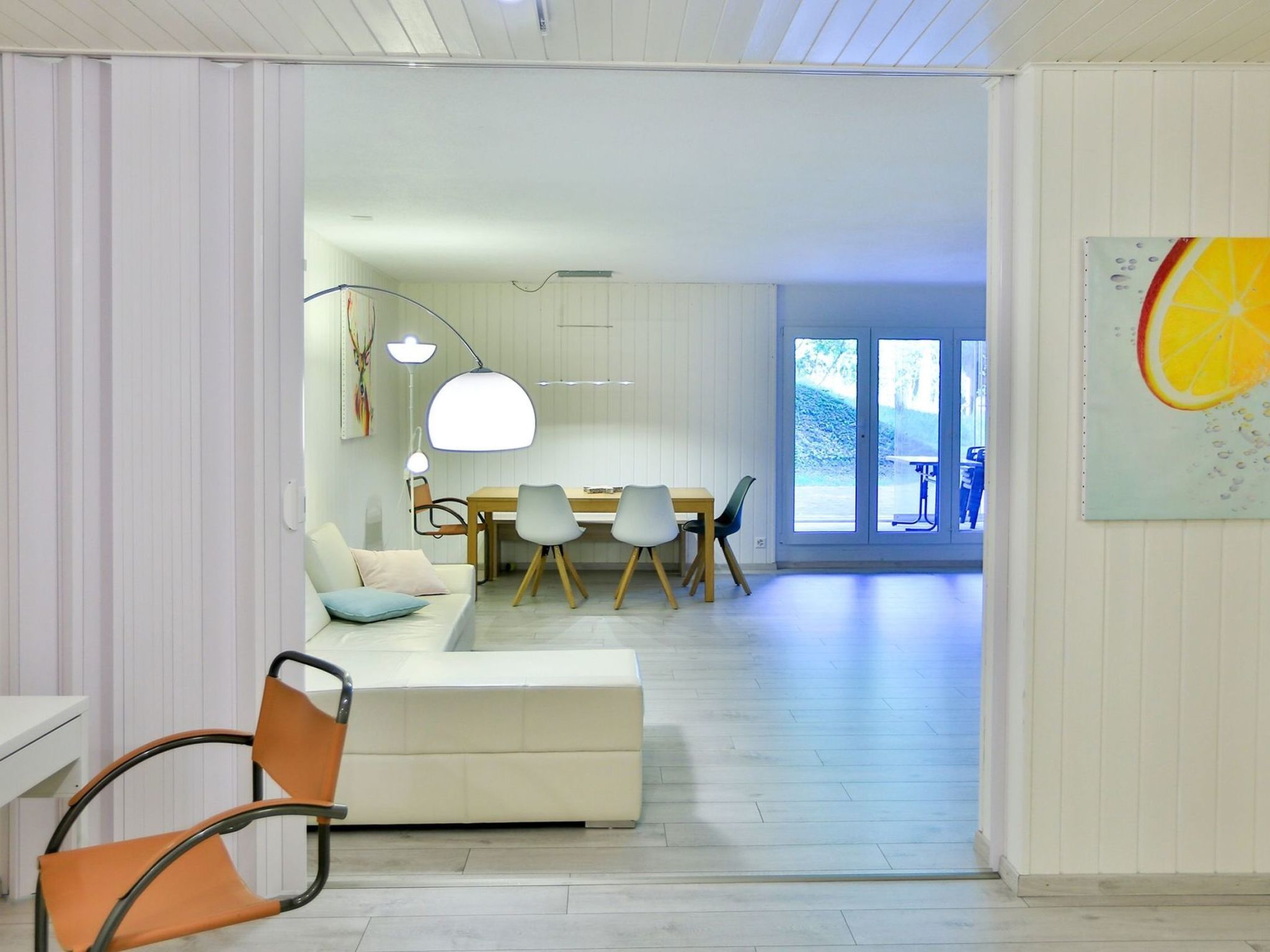 Un intérieur moderne comprenant un coin repas, un canapé et un fauteuil.