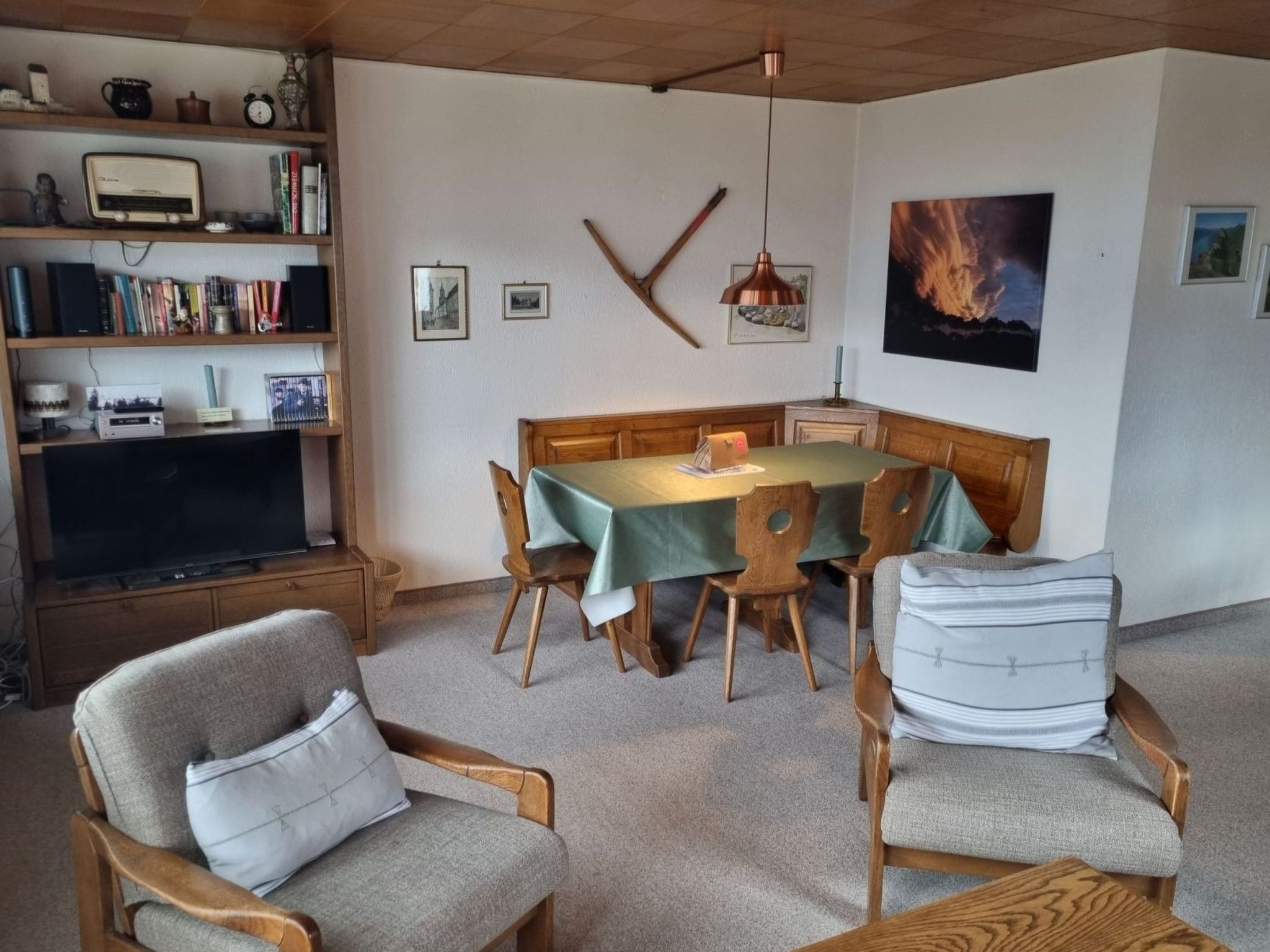 A dining area with a table set for four, surrounded by wooden chairs.