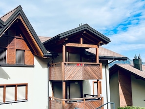 A two-story building with a balcony, wooden shutters, and a sloped roof. - Alpenresidenz (CharmingStay), (Flumserberg Tannenbodenalp), by Interhome (Flumserberg Tannenbodenalp)