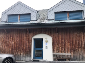 Ein Gebäude mit Holzfassade, einer blauen Tür und einem Schild mit der Nummer 8.