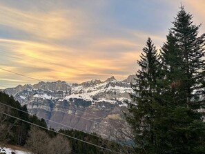 Paisagem montanhosa com picos cobertos de neve e céu claro.