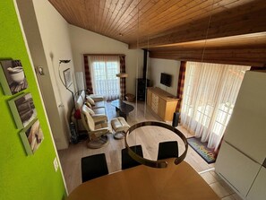 Una cuina moderna amb zona de menjador, sofà i televisió.