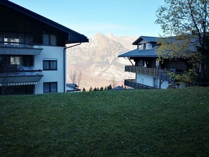 A modern building with a balcony overlooking a mountainous landscape.