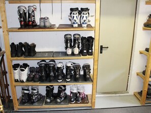 A shoe rack with multiple shelves holding various types of footwear.
