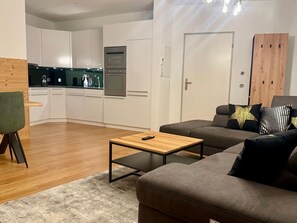 A modern living room with a sofa, a coffee table, and a green chair. - Bergträume Haus Gauen (CharmingStay), (Flumserberg Tannenheim), by Interhome (Flumserberg Tannenheim)