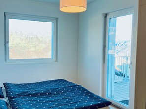 Ein Zimmer mit einem Bett, einem Fenster und einer Tür.