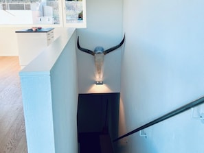 A staircase with a wall-mounted bull's head sculpture. - Panorama View (CharmingStay), (Flumserberg Tannenbodenalp), by Interhome (Flumserberg Tannenbodenalp)