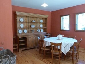 A dining room with a wooden buffet, a round table with chairs, and a window. - Chalet for 12 in the heart of ArÃªches-Beaufort (Arêches-Beaufort)