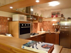 A kitchen with a microwave, oven, sink, and refrigerator. There is a book on the counter. - Chalet for 12 in the heart of ArÃªches-Beaufort (Arêches-Beaufort)