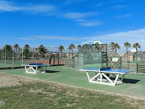 An outdoor tennis court with two tables and a basketball hoop. - Apartment ADA with view - 4 guests (Le Barcarès)