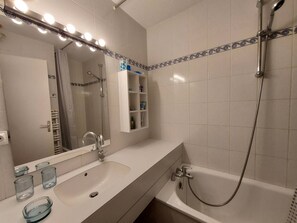 Ein Badezimmer mit Waschbecken, Spiegel und Dusche.