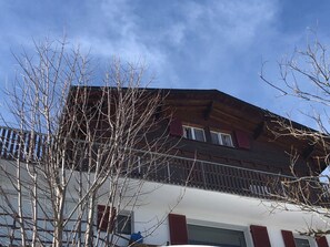 A two-story building with a balcony and a garage. - Chalet Windegg (CharmingStay), (Flumserberg Tannenheim), by Interhome (Flumserberg Tannenheim)