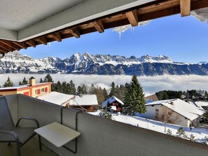 Paisaje nevado de montañas con una vista de un chalet y un telesilla.