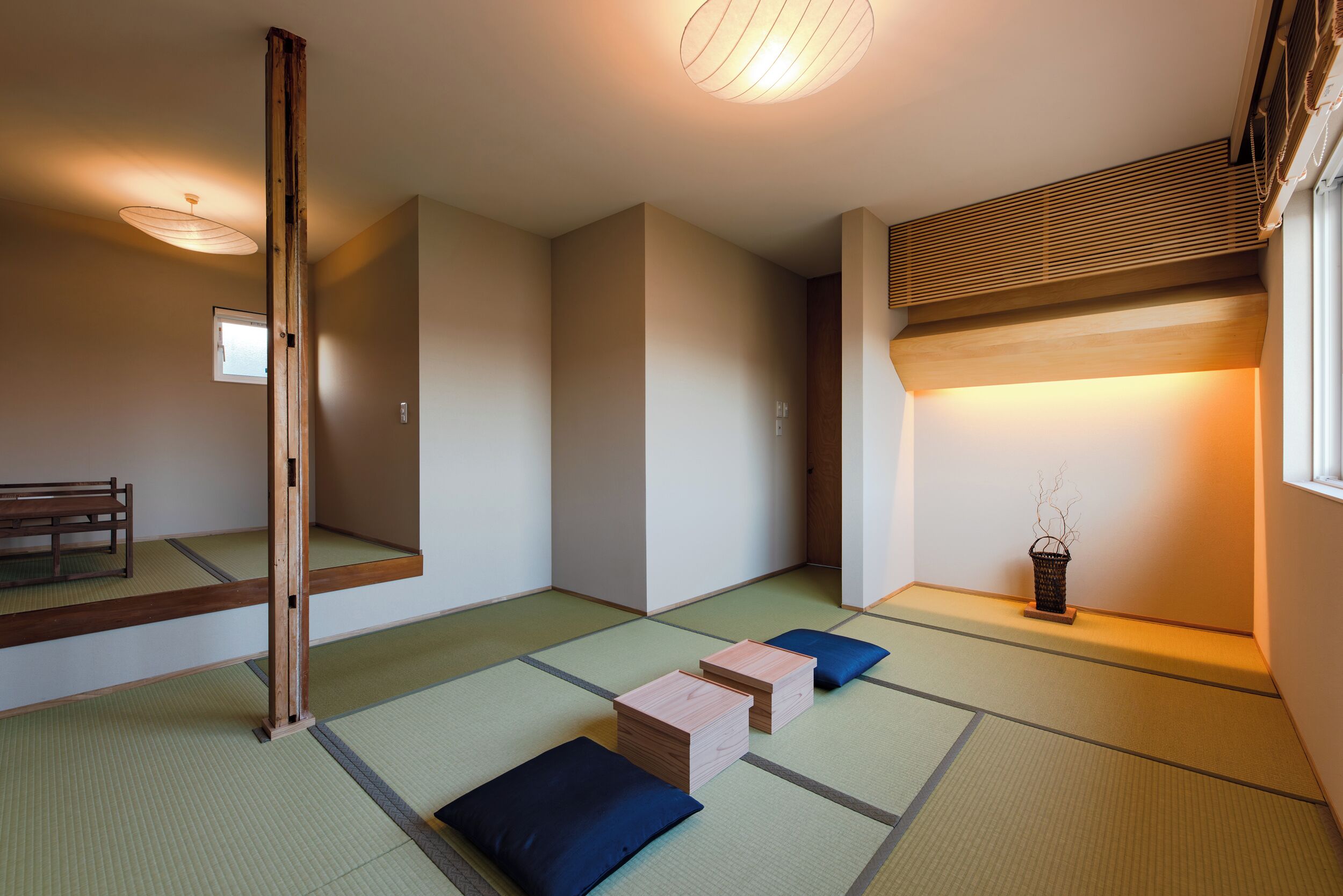 A traditional Japanese room with tatami flooring, a low wooden table, a bench, and a small wooden cabinet.