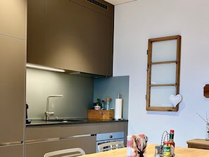 Eine moderne Küche mit Backofen, Spüle und Fenster mit Herz-Dekoration.