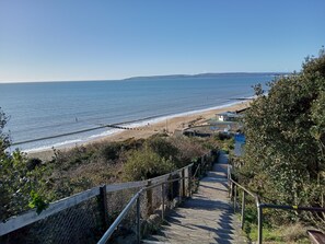Ein Küstenwanderweg führt zu einem Strand mit freiem Blick auf das Meer.