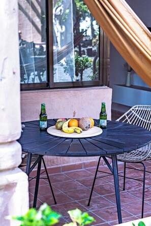 A table with a fruit plate and two bottles, set against a window with a view of greenery. - Salty Casa - Oasis Duna - Corralejo Center (Corralejo)