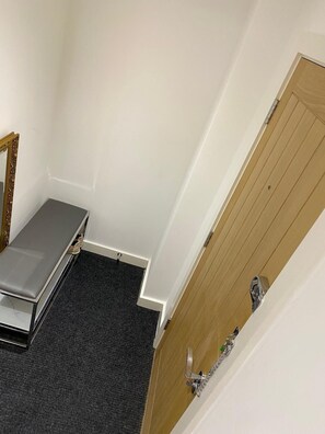 A room with a bed, a wooden door, and a small table. - well furnished flat at city center (Kingston upon Hull)