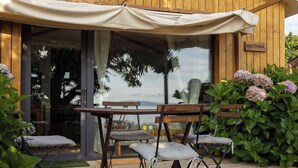 An outdoor seating area with a table and chairs, a wooden fence, and a sign that reads 'BRETEMA'.