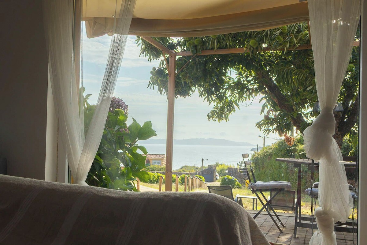 Una stanza con vista sul mare, un pergolato in legno e mobili da esterno.