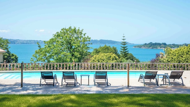 A poolside area with lounge chairs and a view of the sea. - Raíces da costa Ártabra (A Coruña)