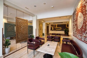 A modern interior with a dining area, seating, and a reception desk. - Touring Pyramids Hotel (Giza Governorate)