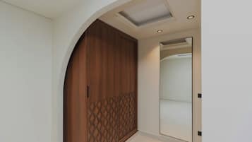 A hallway with a wooden wardrobe, a mirror, and a ceiling light.